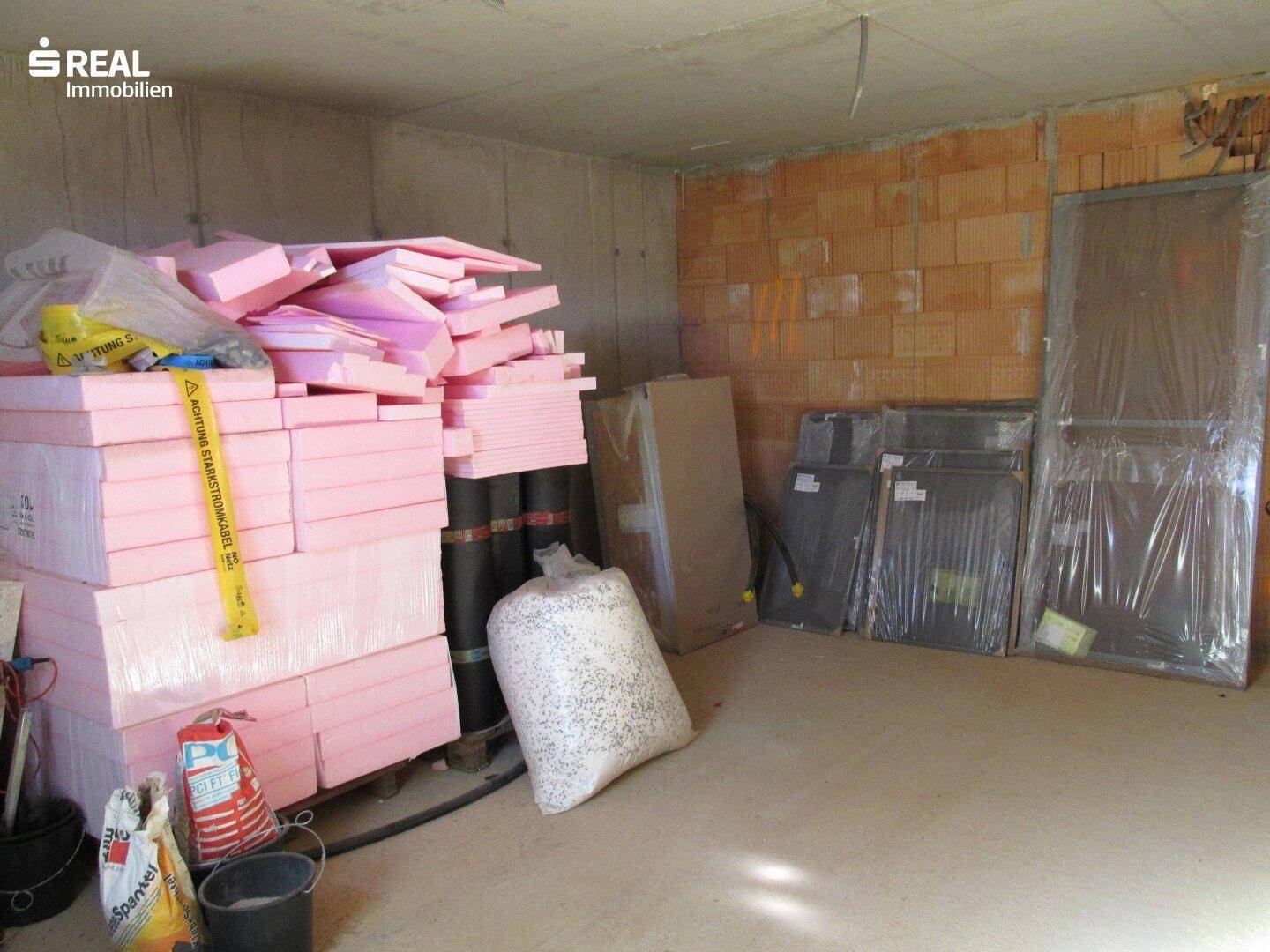 Kellerraum dient als Lager für Baumaterialien wie Dämmplatten und Fensterrahmen.