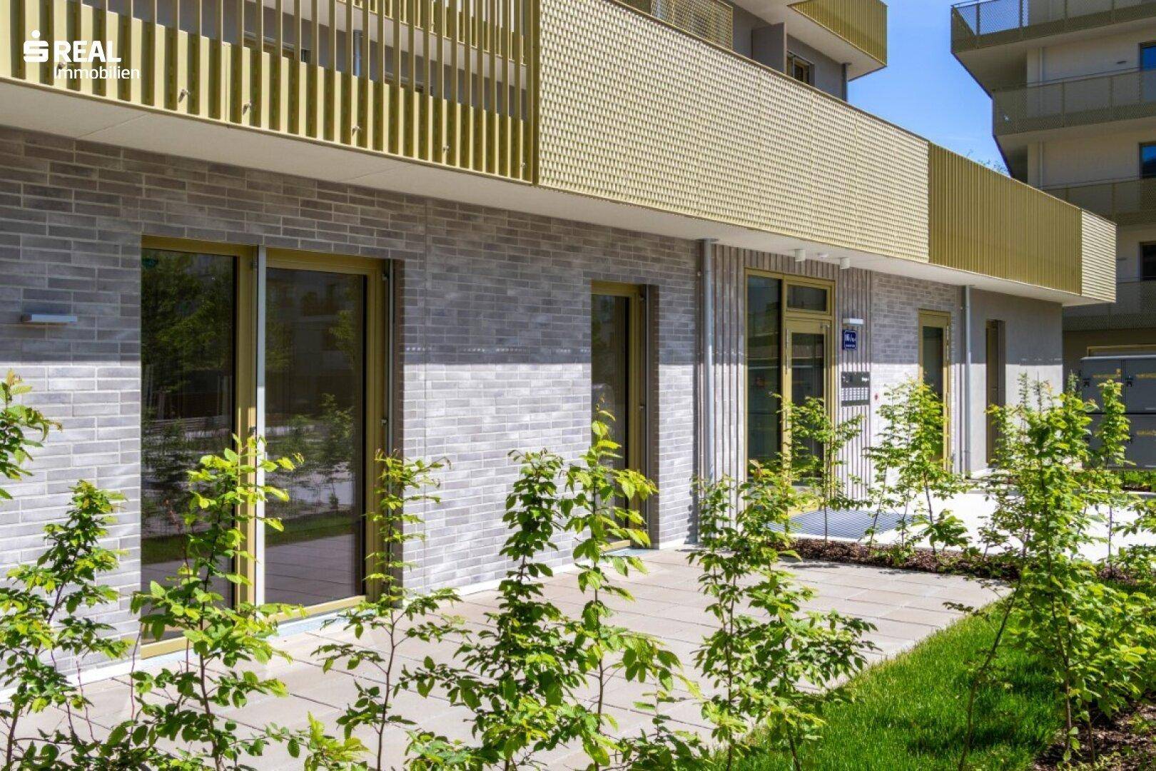 Erdgeschosswohnung mit Zugang zu einer kleinen Terrasse und begrüntem Außenbereich.
