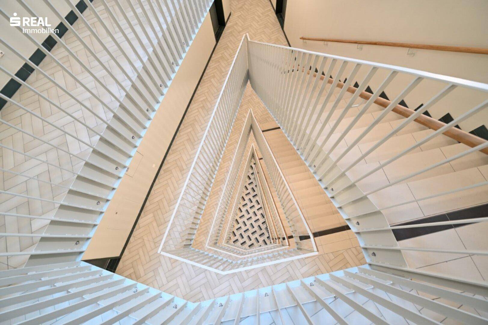 Architektonische Draufsicht auf ein modernes Treppenhaus mit geometrischem Bodenmuster.
