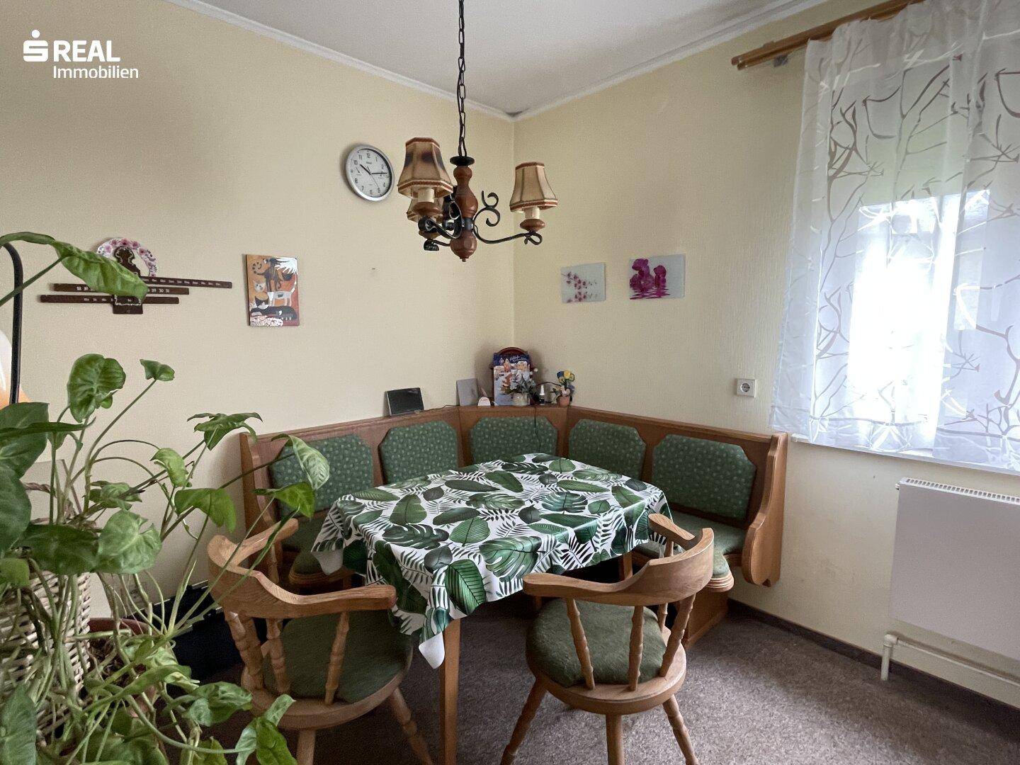 Gemütliche Essecke mit traditionellen Holzmöbeln und gepolsterten Bänken, ideal für Familienmahlzeiten.