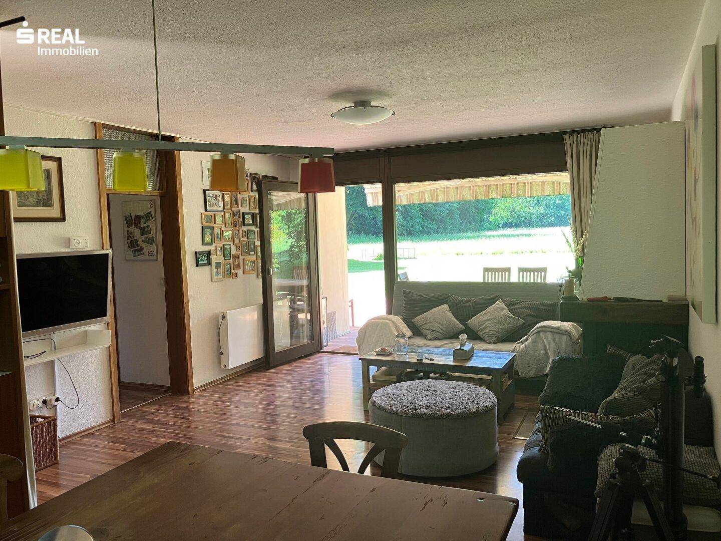 Heller Wohnbereich mit Zugang zur Terrasse und Blick in den Garten.