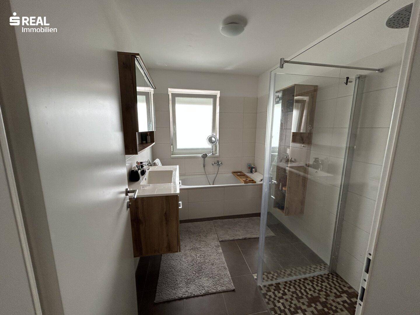 Modernes Badezimmer mit Badewanne, begehbarer Dusche und Doppelwaschbecken.