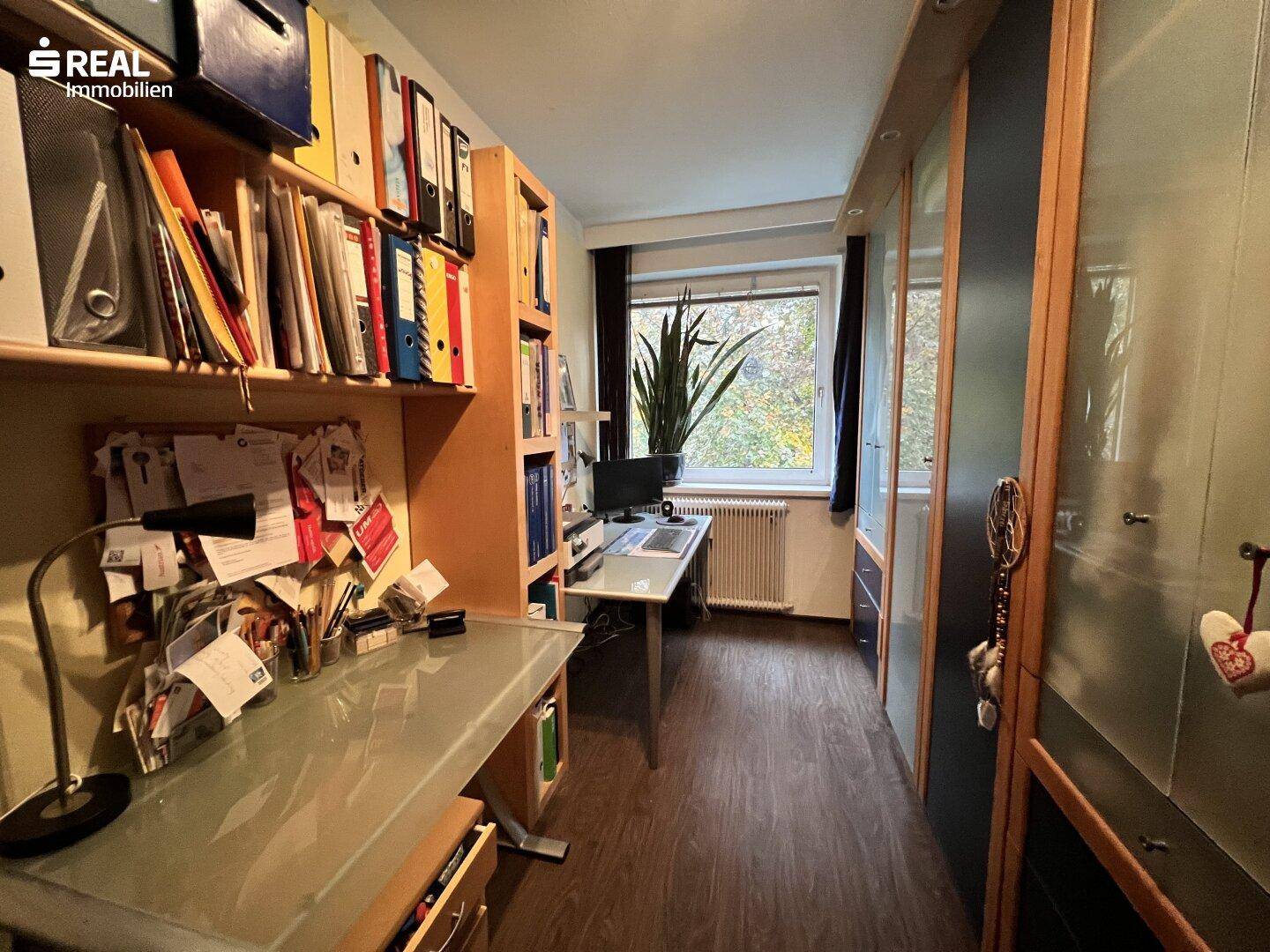 Funktionales Büro mit großem Schreibtisch, Bücherregalen und viel Stauraum.