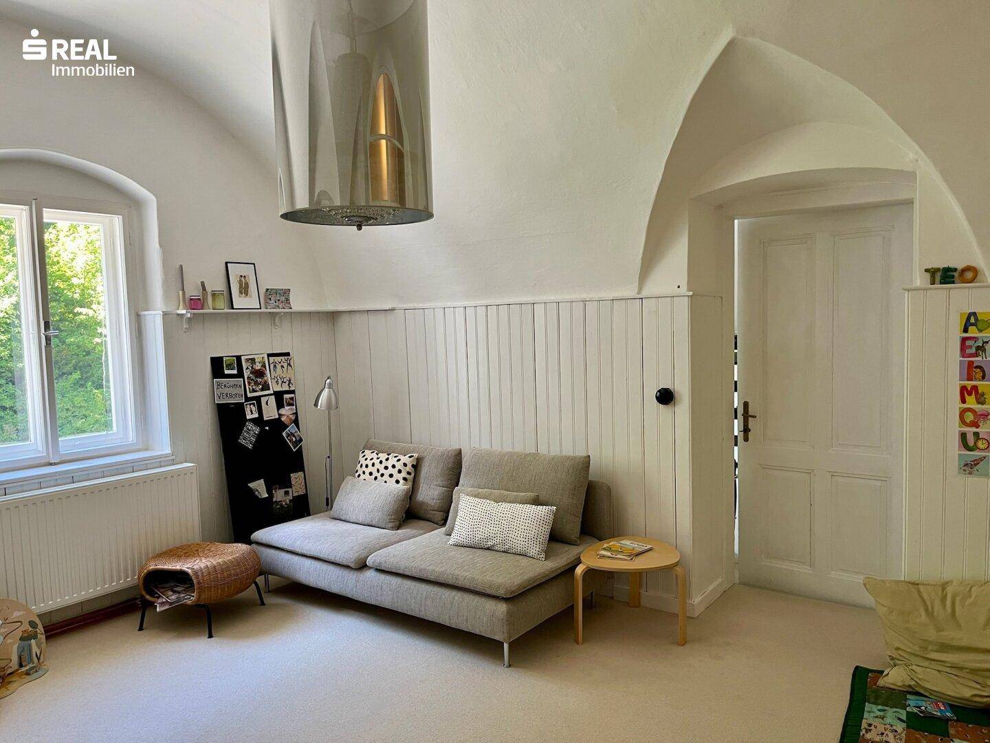 Gemütlicher Raum mit gewölbter Decke und hellem Interieur, ideal als Wohn- oder Arbeitszimmer.