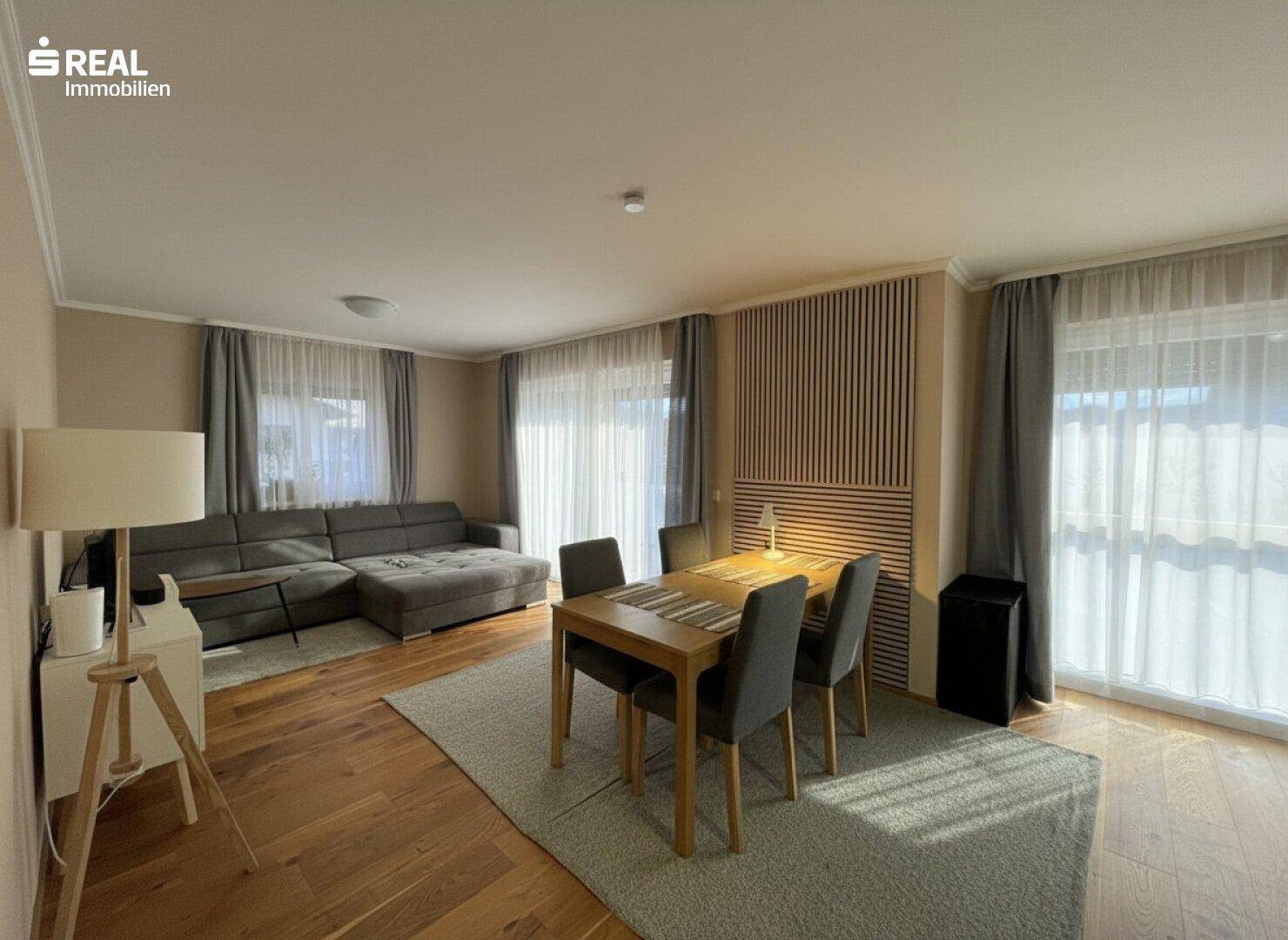 Heller, offener Wohn- und Essbereich mit Holzboden und modernem Design.