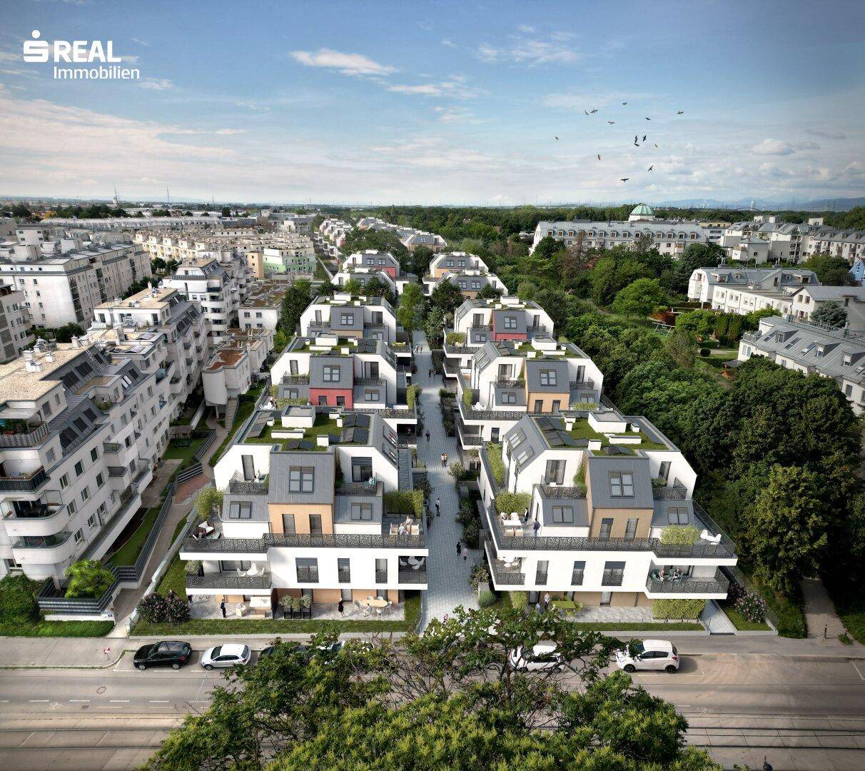 Weitläufige Luftaufnahme einer modernen Wohnsiedlung mit Straßen und vielen Grünflächen.