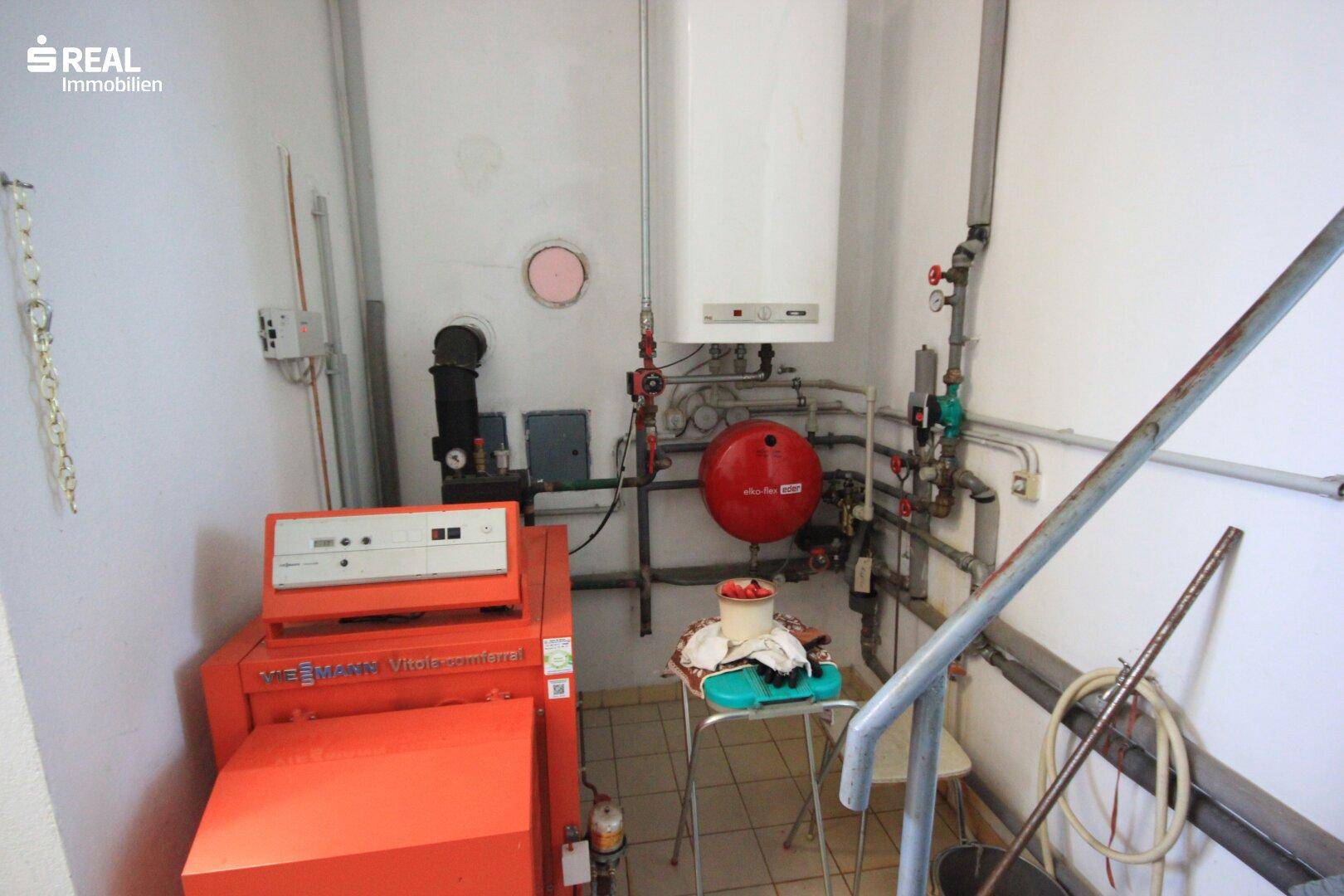 Heizraum mit Boiler, Rohren und technischer Ausstattung für die Wärmeversorgung.