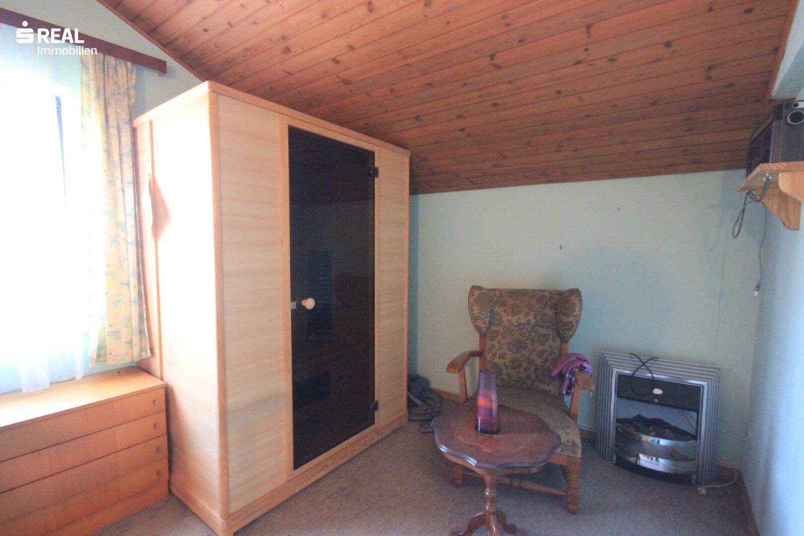 Ausgebauter Dachboden mit Holzdecke, Fenster und einer integrierten Sauna.