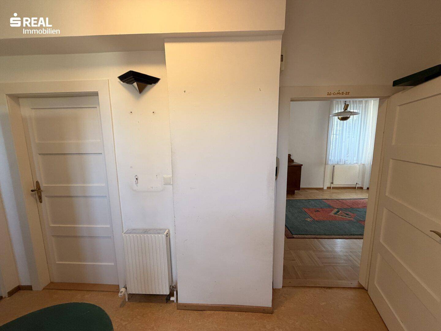Heller Flurbereich mit Parkettboden und Zugang zu verschiedenen Zimmern im Erdgeschoss.