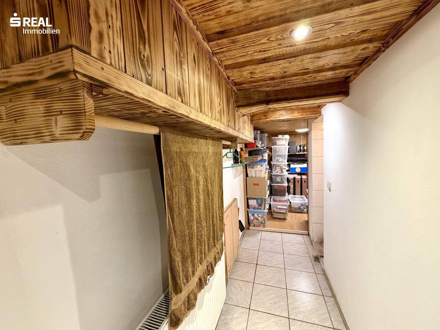 Kellergang mit Holzdecke und Regalen für Lagerung.