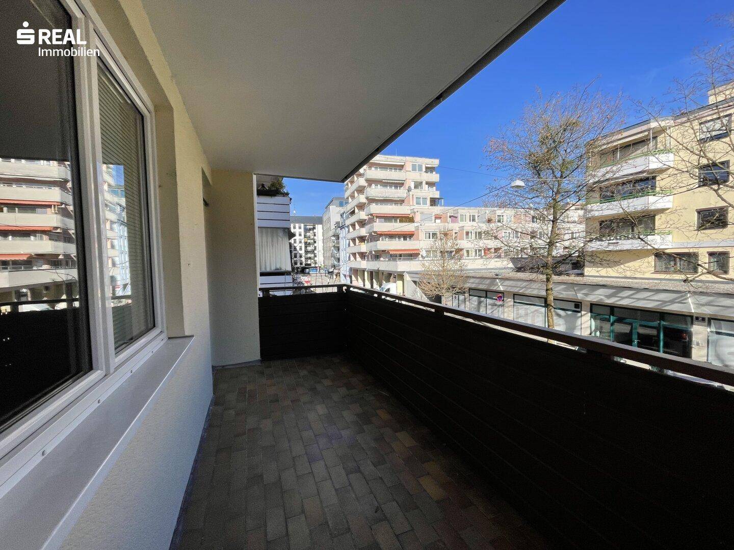 Geräumiger Balkon mit Blick auf die umliegenden Gebäude und die Stadt.