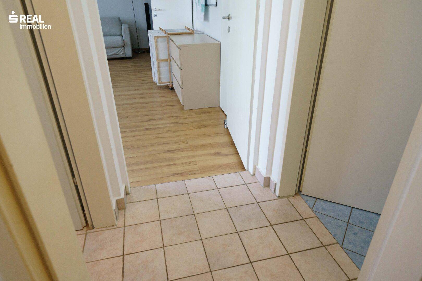 Übergangsbereich mit Fliesenboden und Laminat, der verschiedene Räume verbindet.