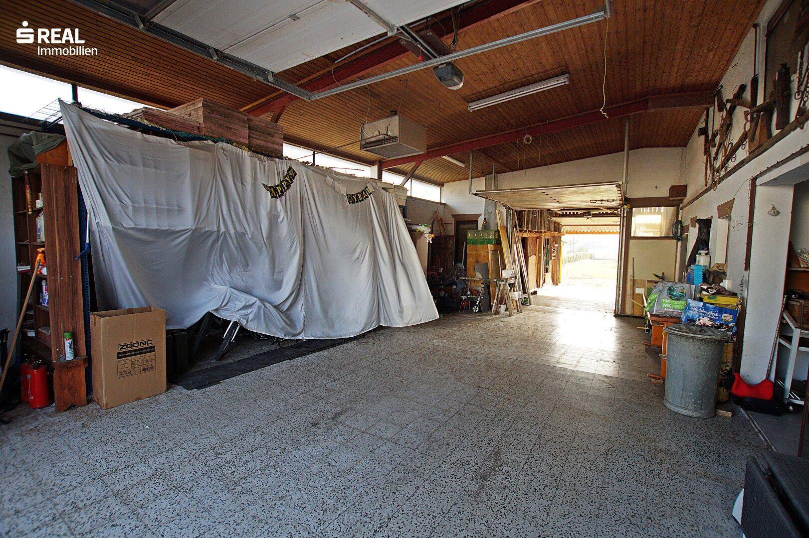 Geräumige Garage mit viel Stauraum und einem überdachten Fahrzeug.