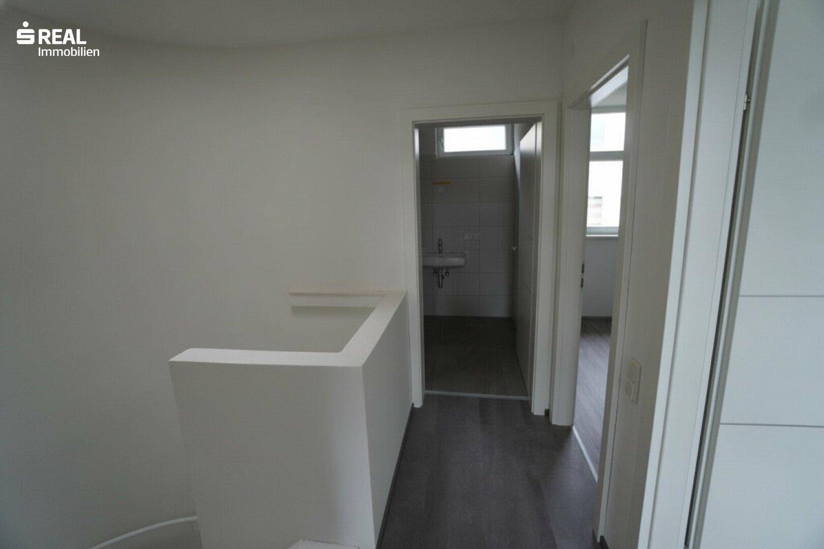 Oberer Flur mit Blick auf das Badezimmer und weitere Zimmer.