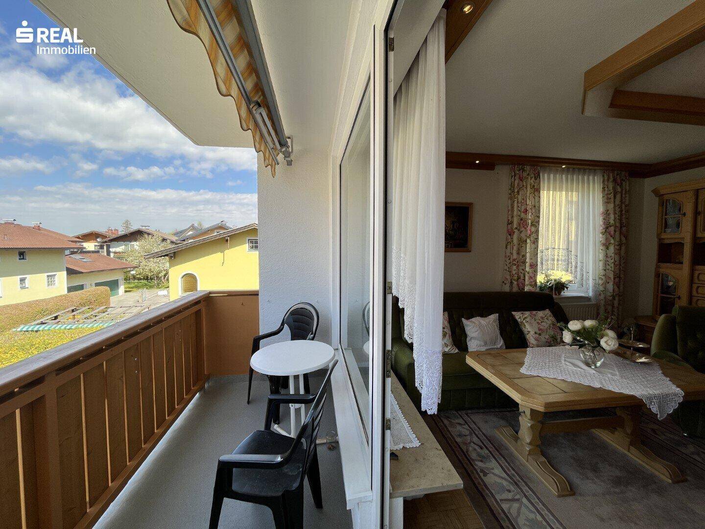 Gemütliches Wohnzimmer mit Zugang zum Balkon und Blick auf die Umgebung.