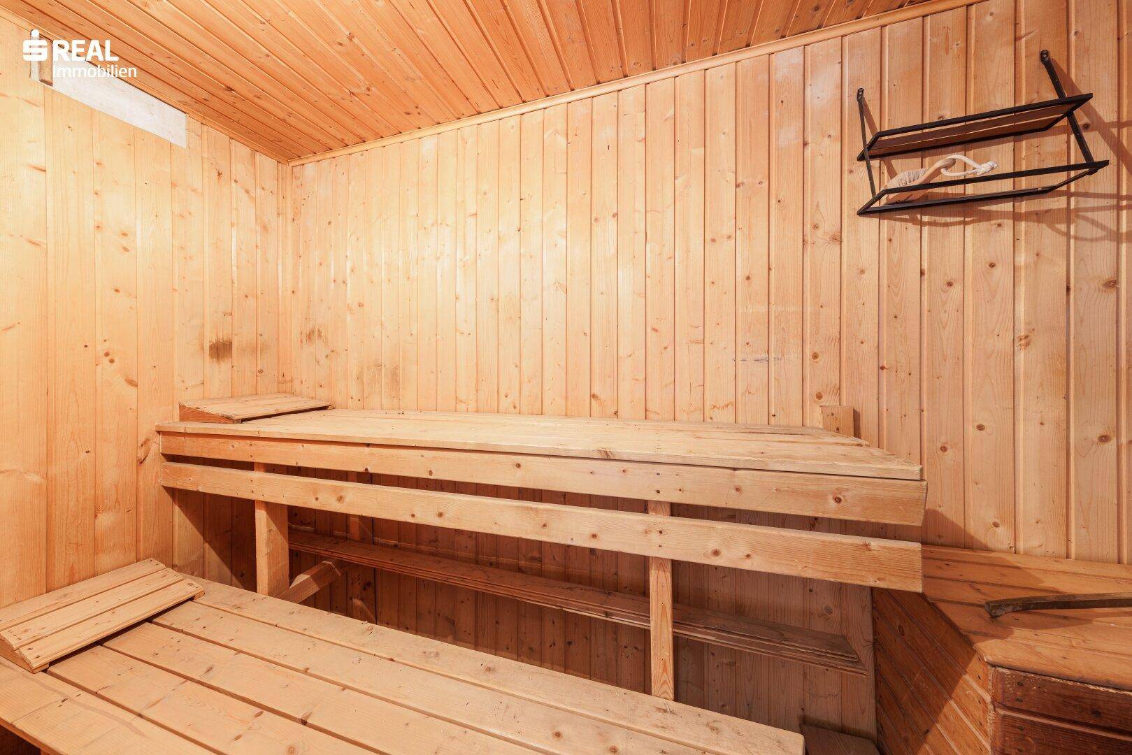 Private Sauna mit Holzverkleidung und Sitzbänken für Entspannung.