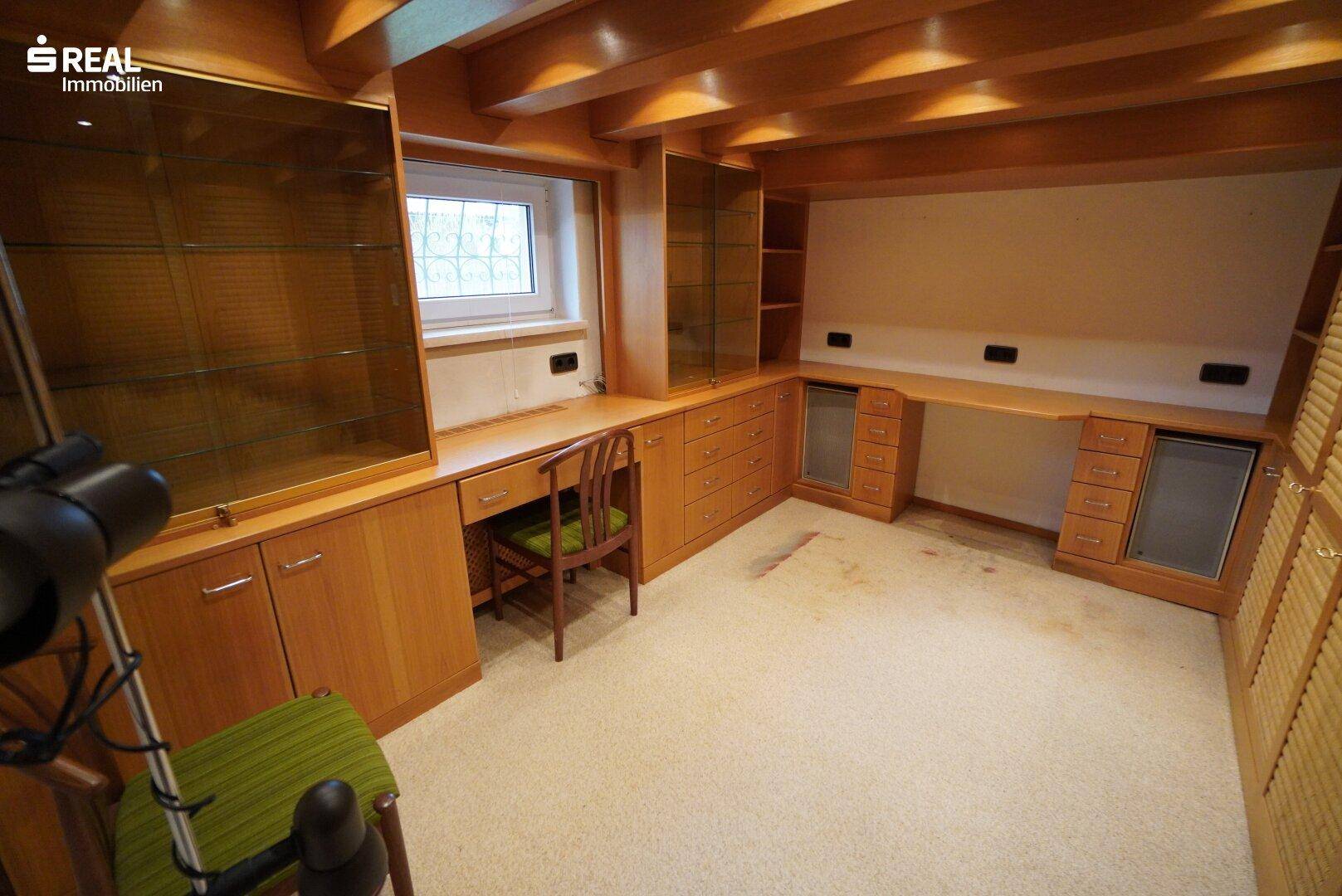 Arbeitszimmer mit maßgefertigten Holzmöbeln, Schreibtisch und Fenster.