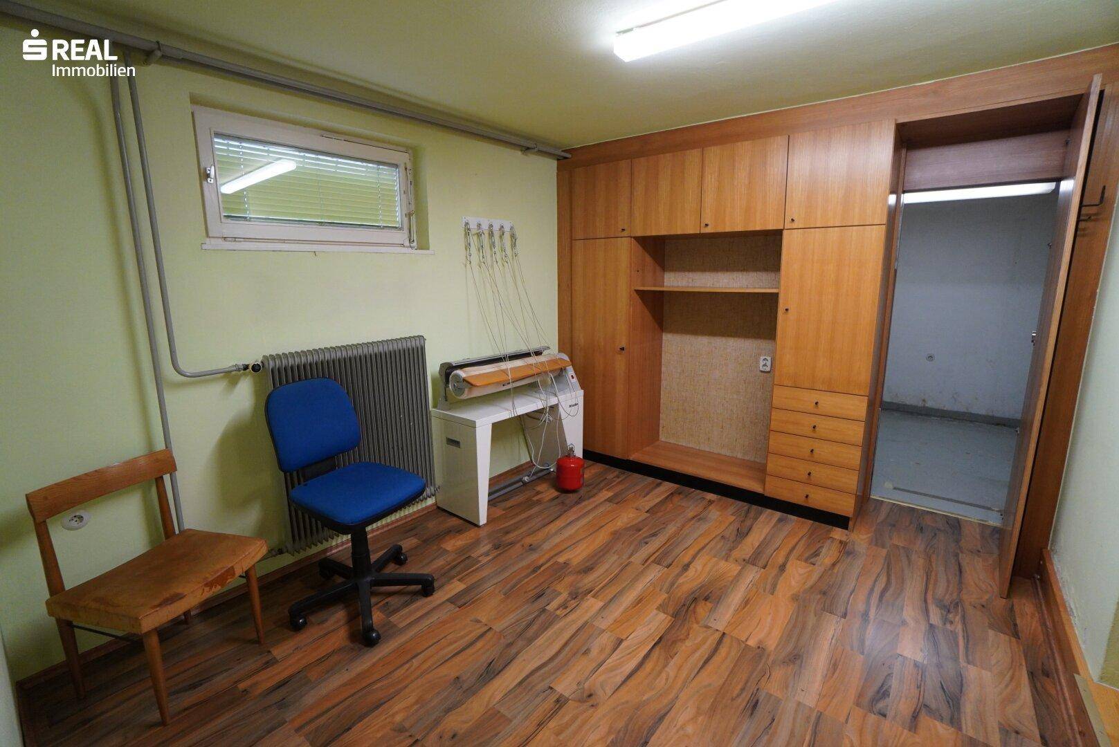 Praktischer Hauswirtschaftsraum mit Holzschränken, Fenster und Arbeitsbereich.