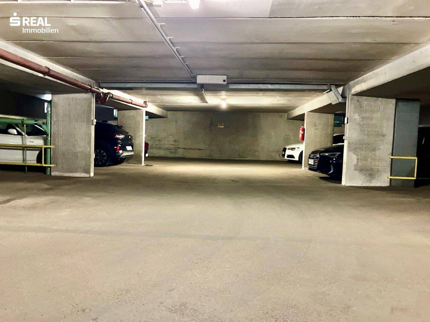 Tiefgarage mit mehreren Stellplätzen und Betonwänden.