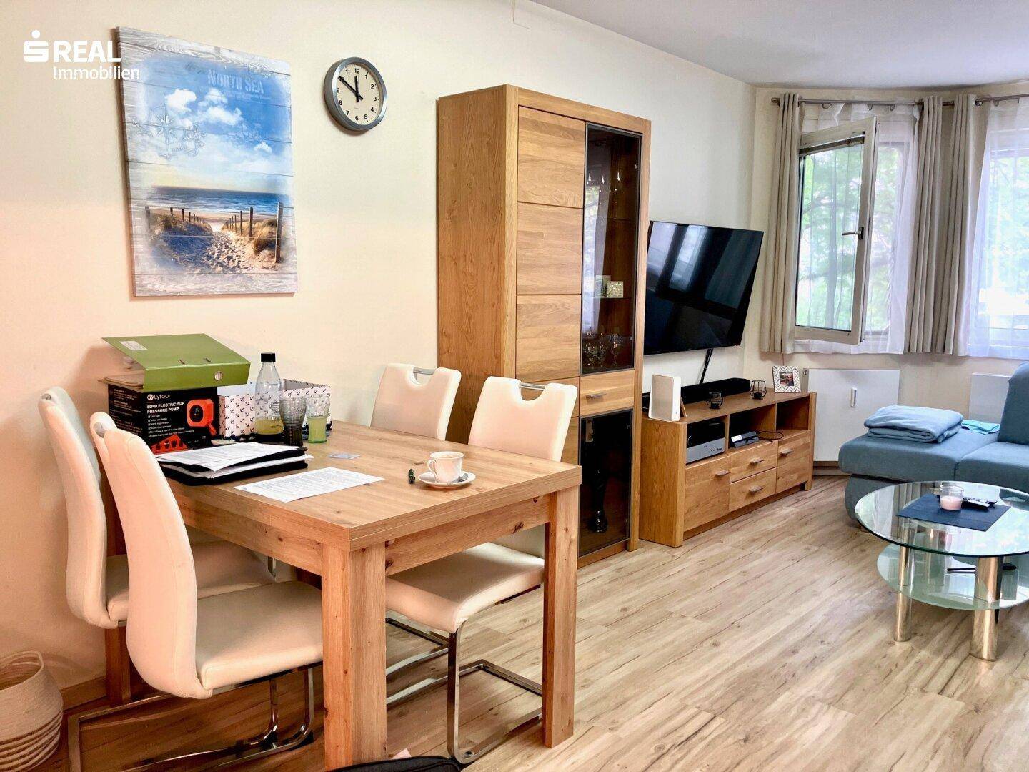 Heller Wohn-Essbereich mit Esstisch, Sideboard und bequemer Sitzecke am Fenster.