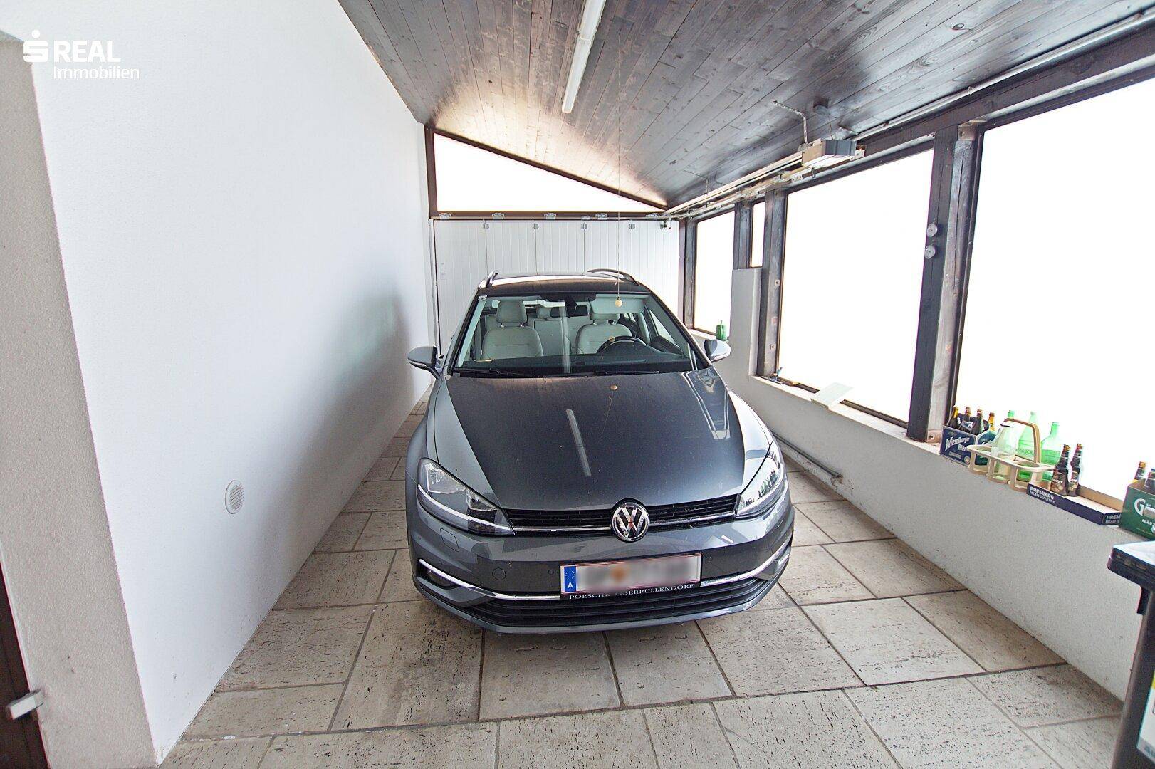 Geräumige Garage mit Fliesenboden und Fenster, bietet Platz für ein Fahrzeug und Lagerung.