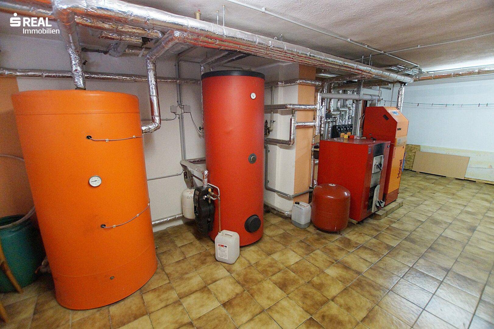 Heizraum im Keller mit großen Warmwasserspeichern und Heizungsanlage.