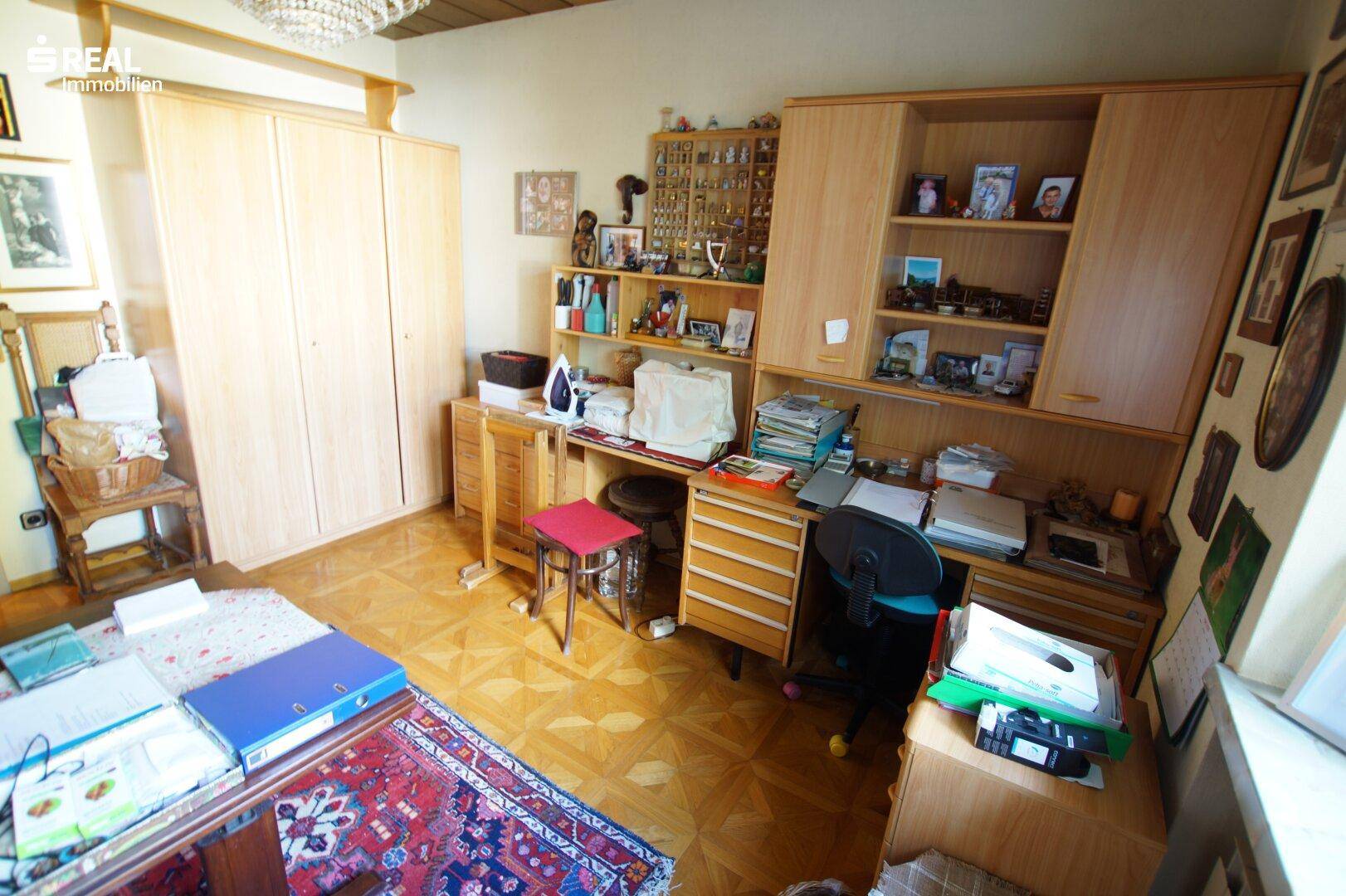 Funktionales Zimmer mit Schreibtisch, Schränken und Stauraum, gut organisiert für verschiedene Nutzungen.