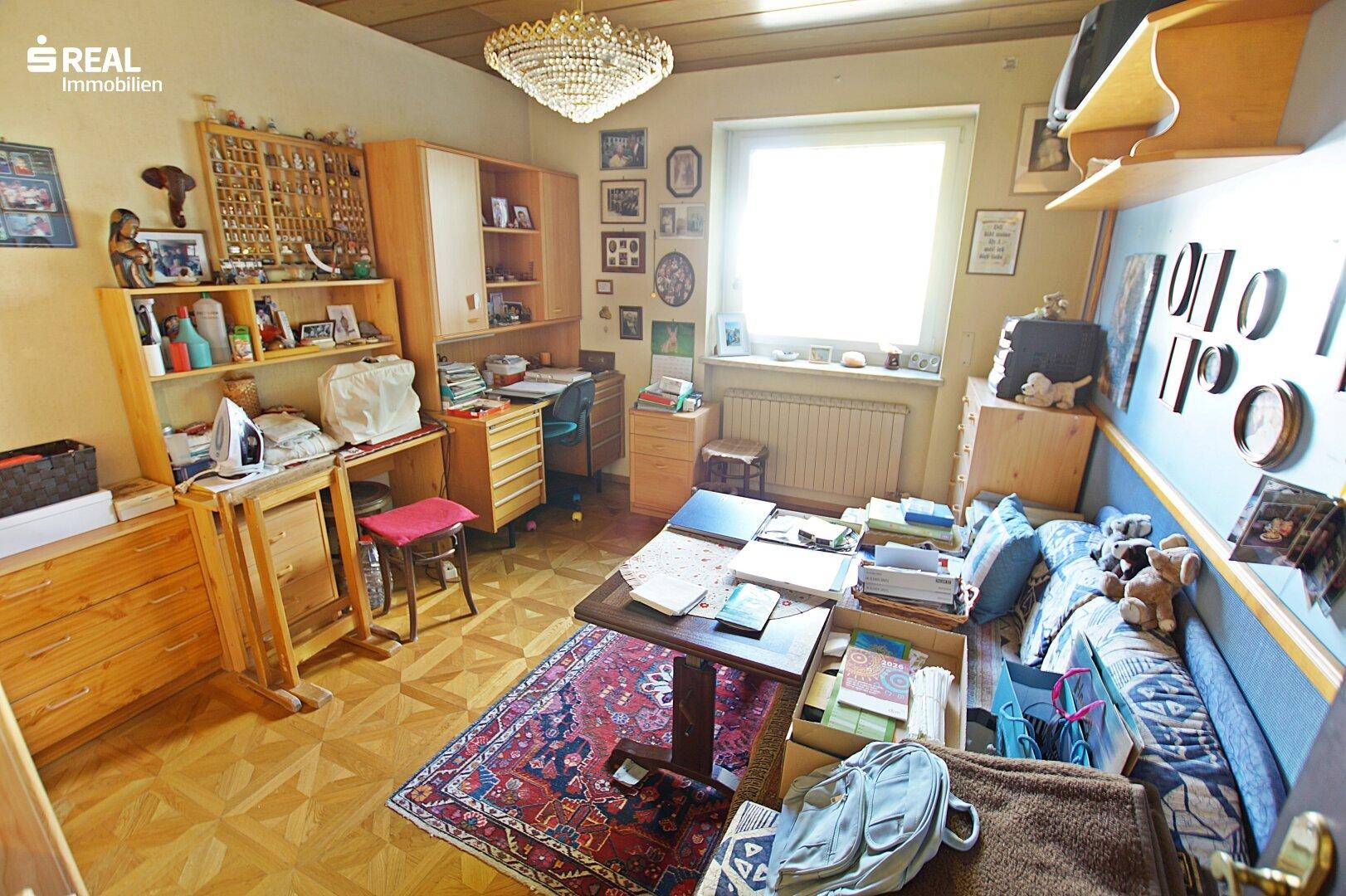 Vielseitiges Zimmer mit Schreibtisch, Stauraum und Schlafgelegenheit, ideal als Gäste- oder Arbeitszimmer.