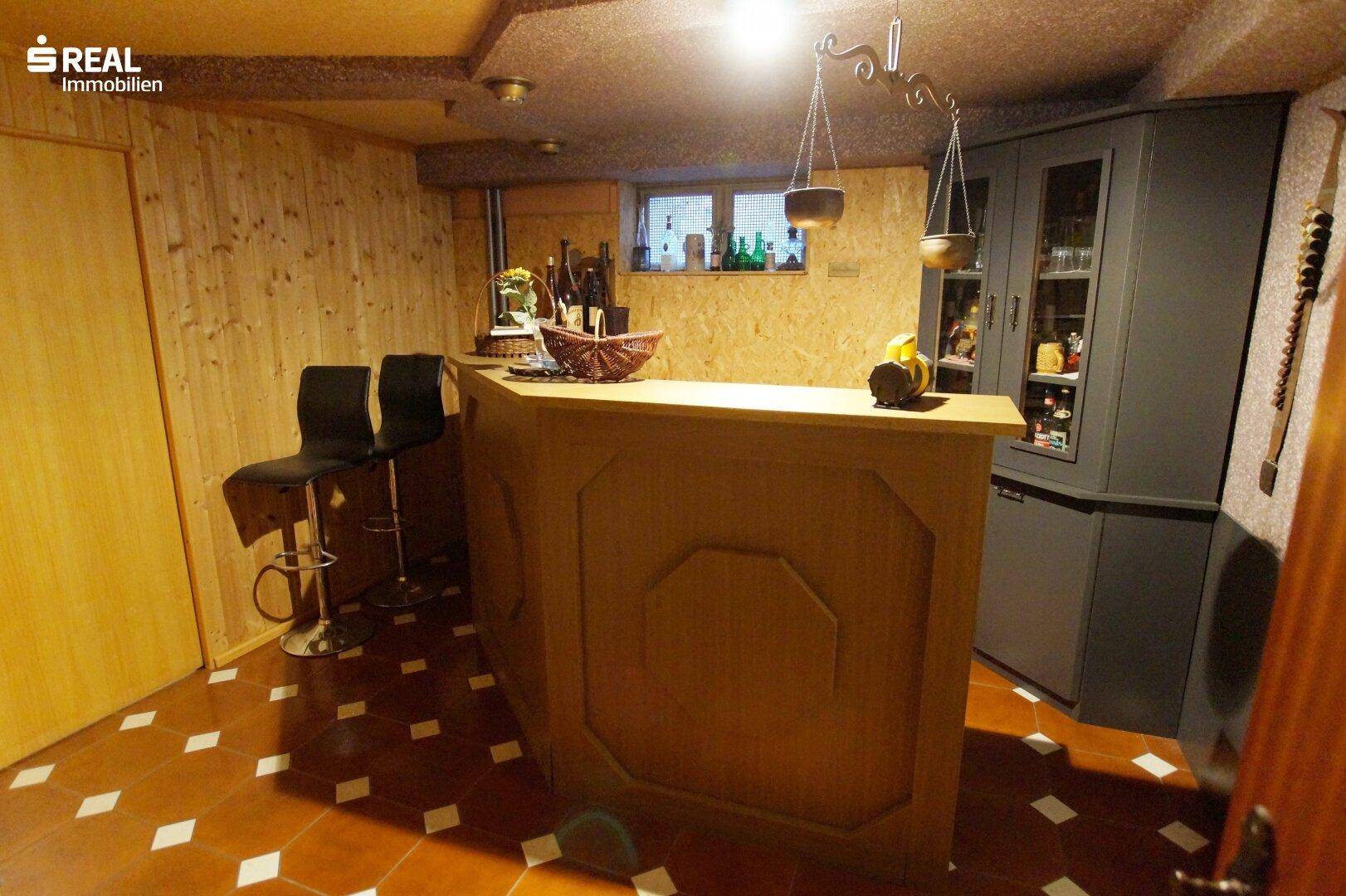Kellerbar mit Holzverkleidung und Hockern, perfekt für Unterhaltung und Weinlagerung.