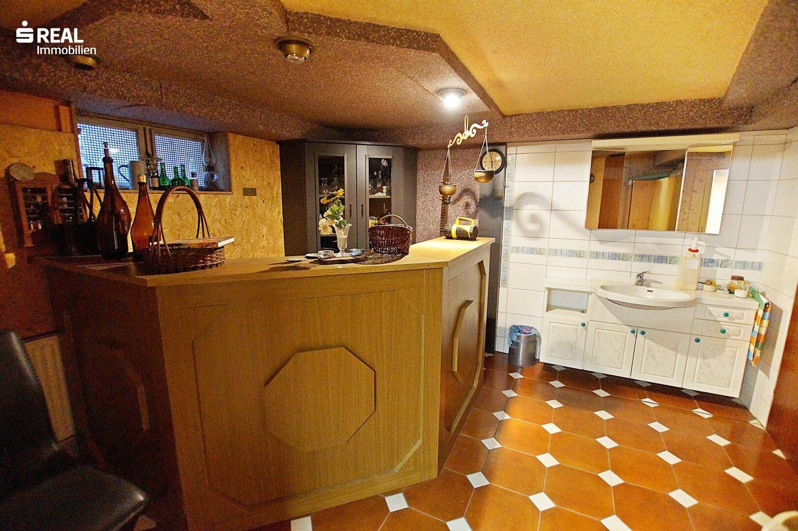Gemütlicher Partyraum im Keller mit Bar und Waschbecken, ideal für gesellige Abende.