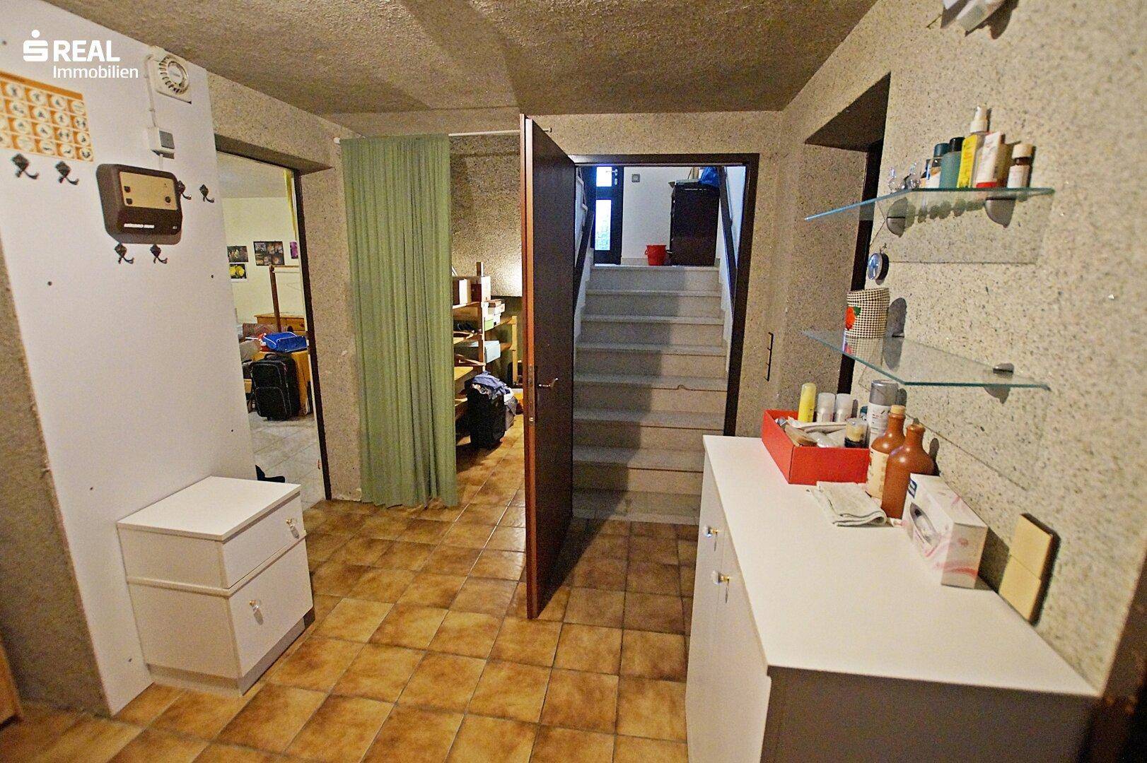 Kellerflur mit Zugang zu verschiedenen Räumen und Treppe zum Obergeschoss.