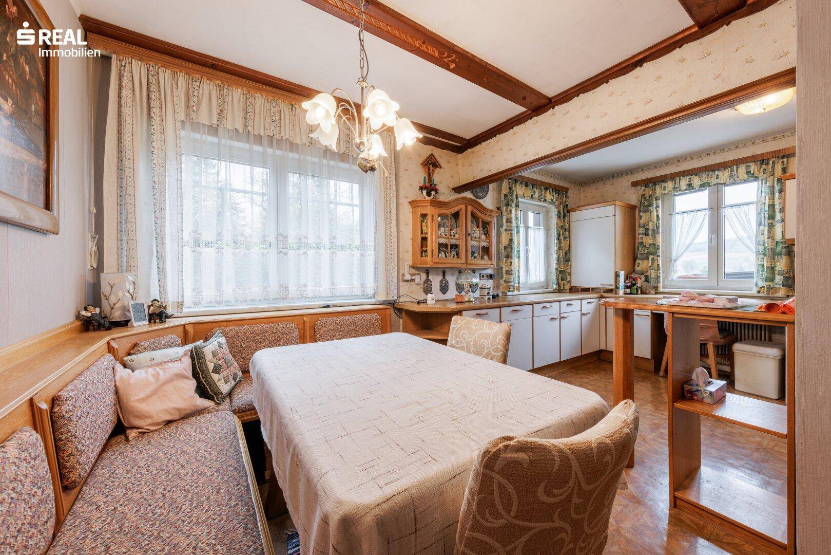 Geräumige Wohnküche mit Essbereich, Holzmöbeln und traditioneller Einrichtung.