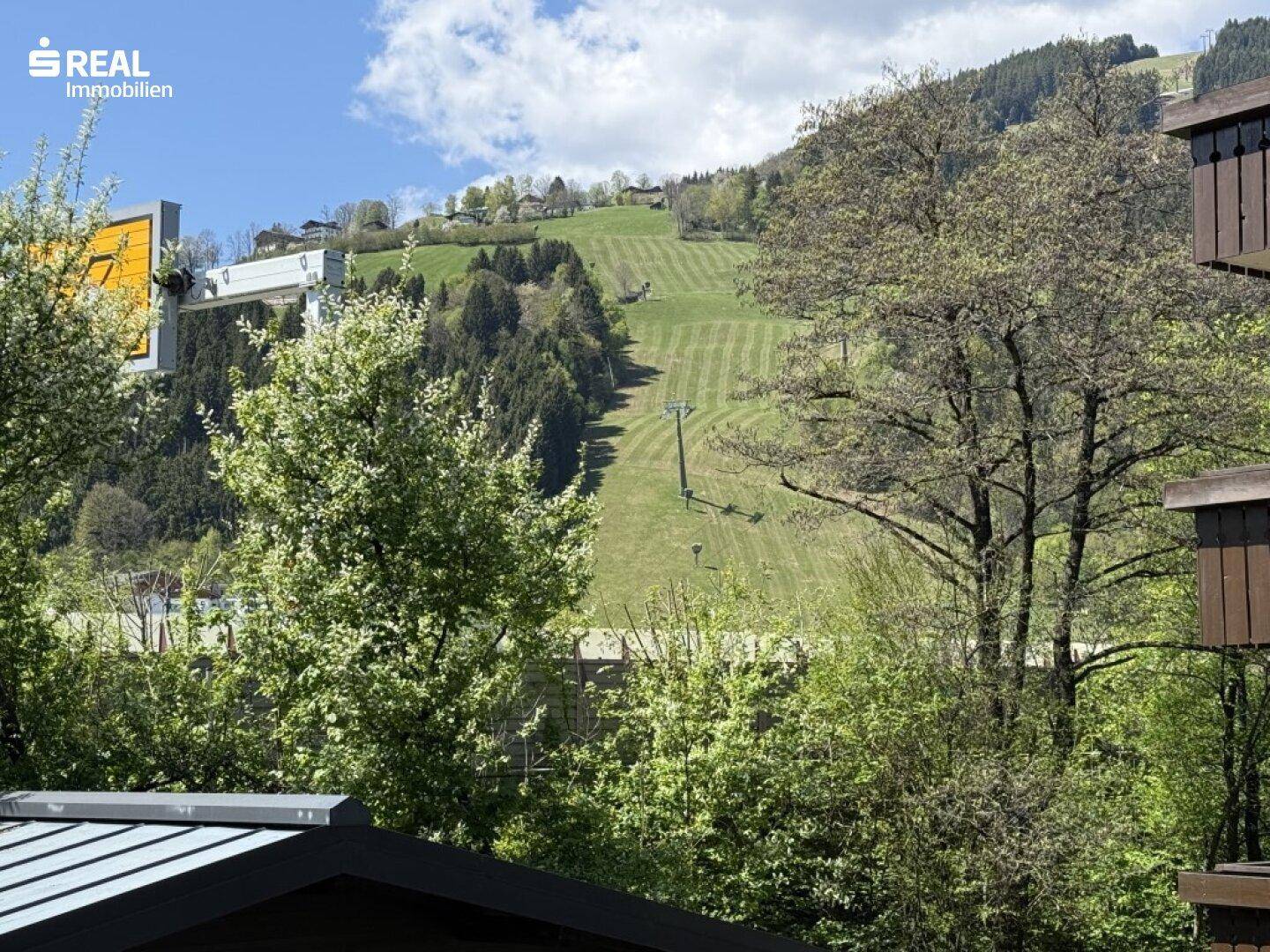 Weitläufiger Blick auf die grünen Hügel und die Berglandschaft mit Skilift.