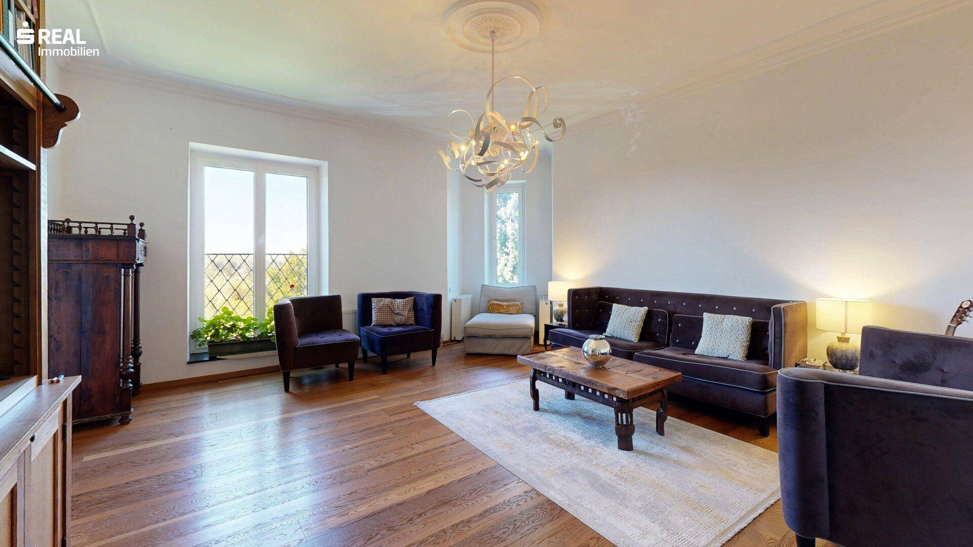 Elegantes Wohnzimmer mit hohen Decken, Parkettboden und stilvoller Beleuchtung.
