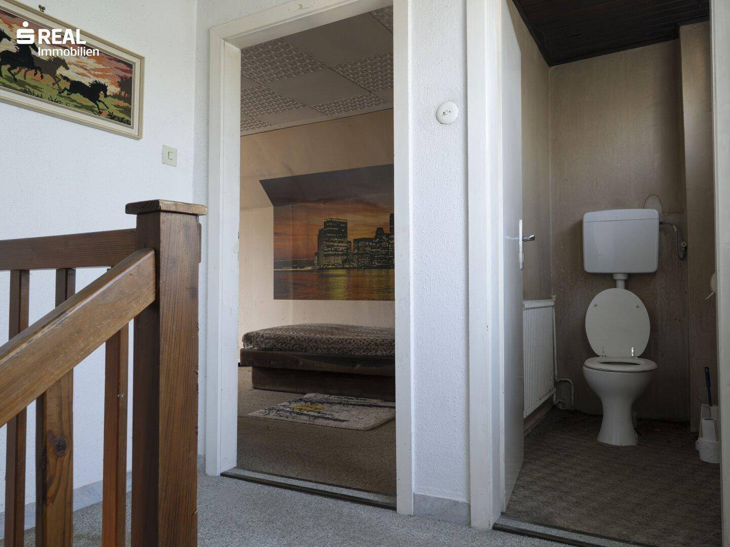 Flur im Obergeschoss mit Zugang zu einem Schlafzimmer und einer separaten Toilette.