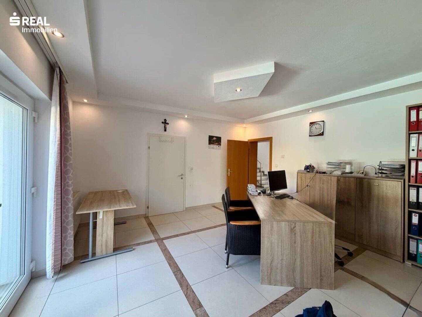 Helles Büro mit Fliesenboden, großem Fenster und Blick ins Grüne, ideal für Home-Office.