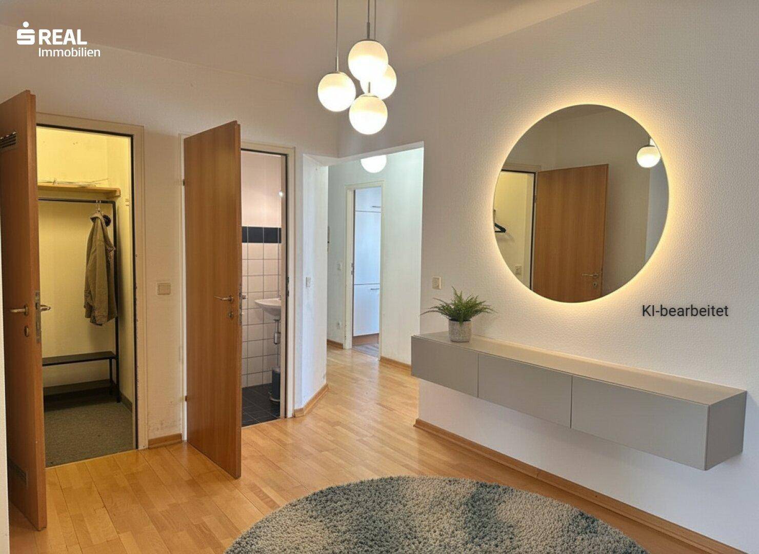 Moderner Flur mit beleuchtetem Spiegel, schwebendem Sideboard und Holzboden.