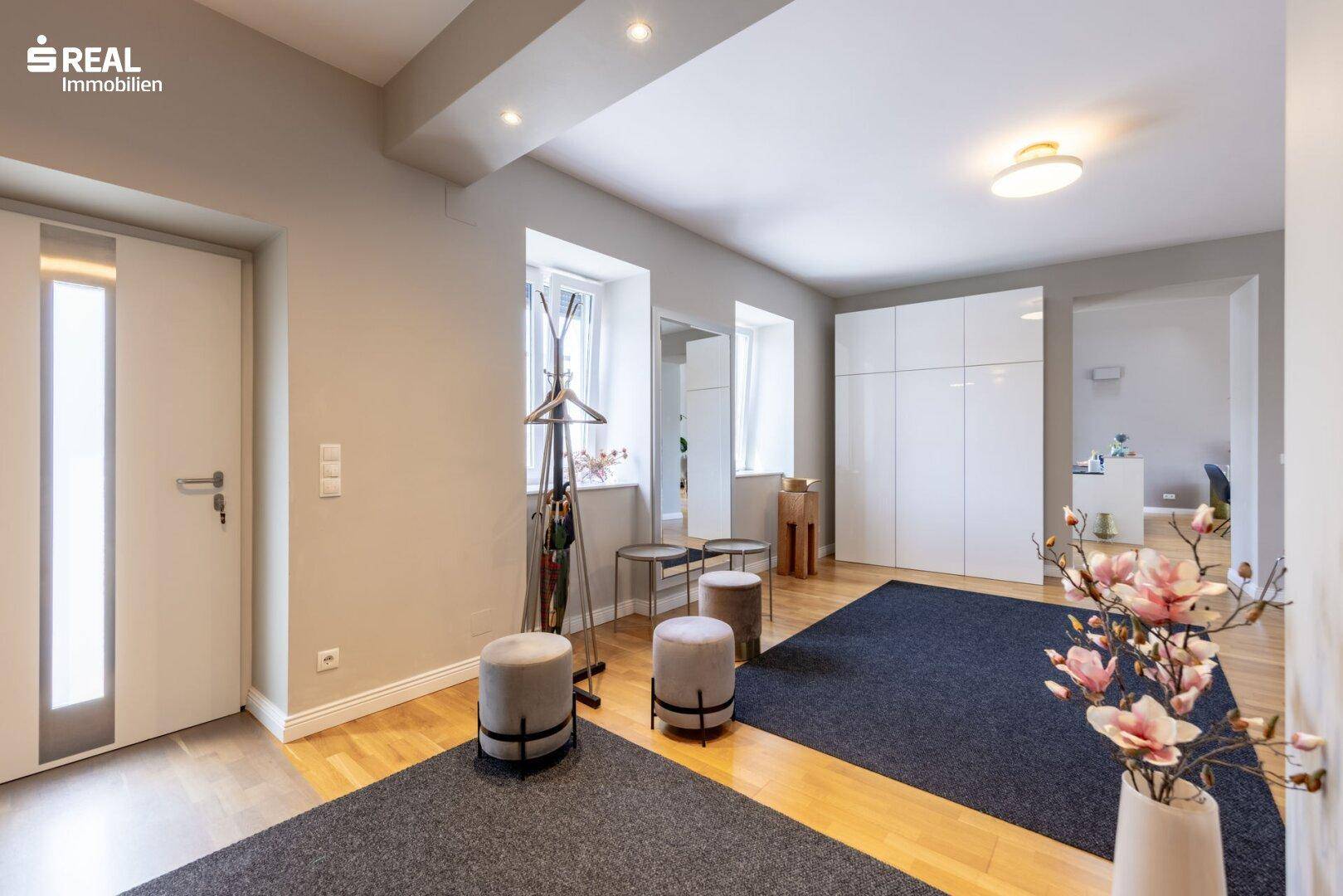 Moderner Eingangsbereich mit Garderobe, Spiegeln und praktischen Aufbewahrungsmöbeln.