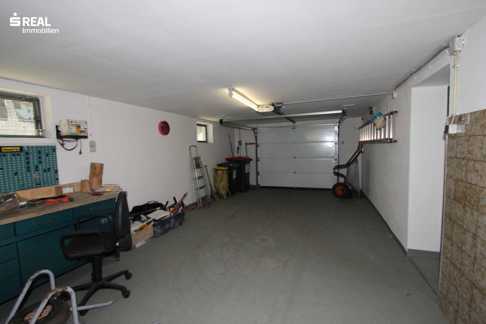 Geräumige Garage mit Werkbank und Stauraum, ideal für Fahrzeuge und Hobbys.
