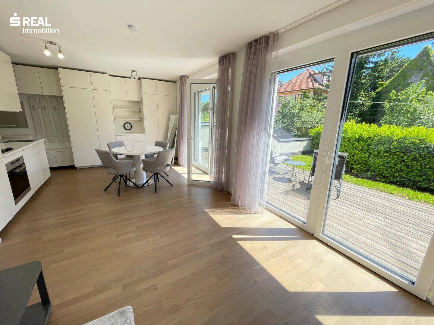 Offener Wohnbereich mit Essplatz, integrierter Garderobe und Zugang zur sonnigen Holzterrasse.