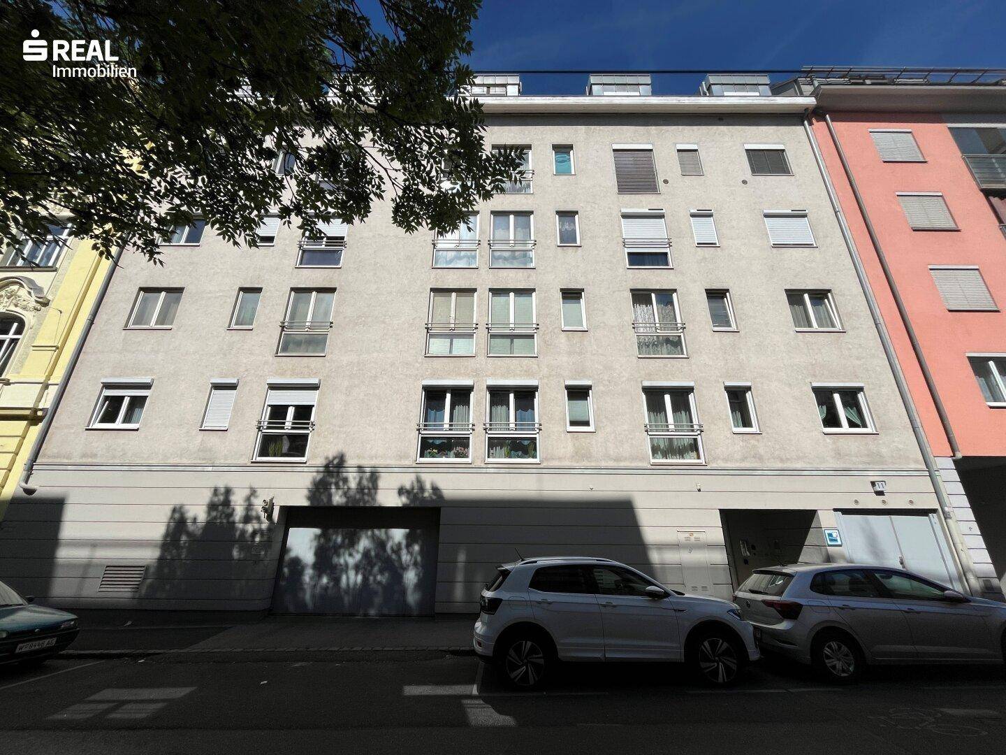 Mehrstöckiges Wohngebäude mit zahlreichen Fenstern und Balkonen in städtischer Umgebung.
