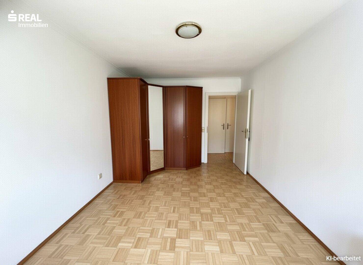 Schlafzimmer mit Parkettboden und großem Kleiderschrank, bietet viel Stauraum.
