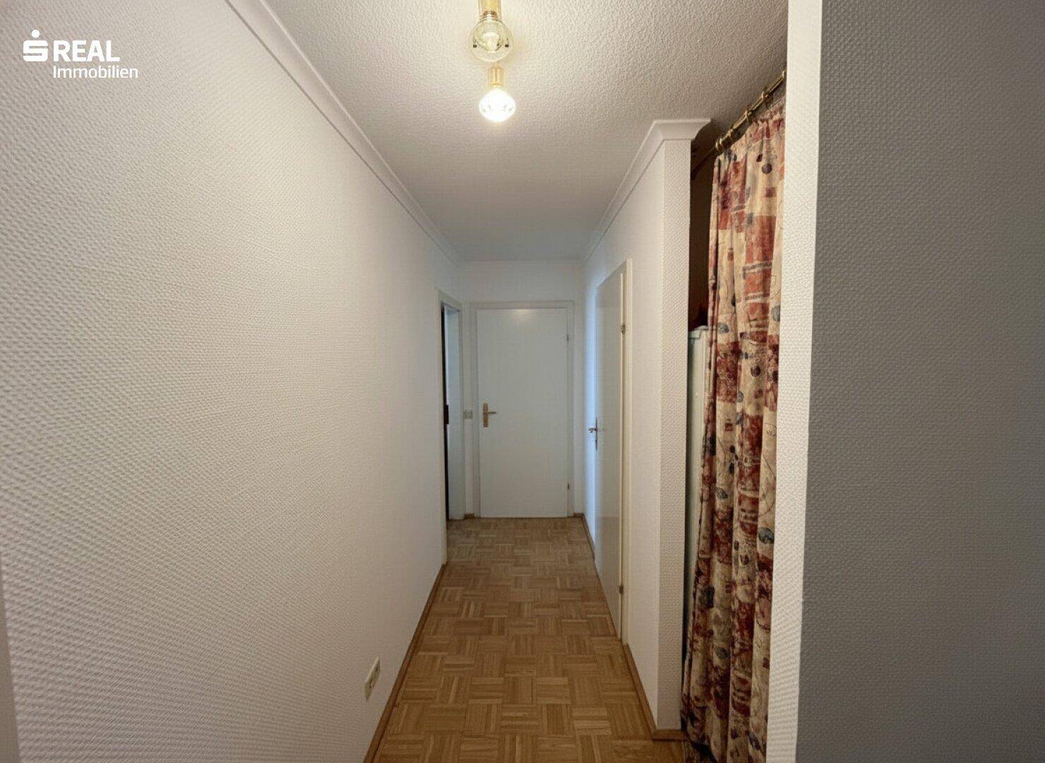 Heller Flur mit Parkettboden und Zugang zu verschiedenen Zimmern der Wohnung.