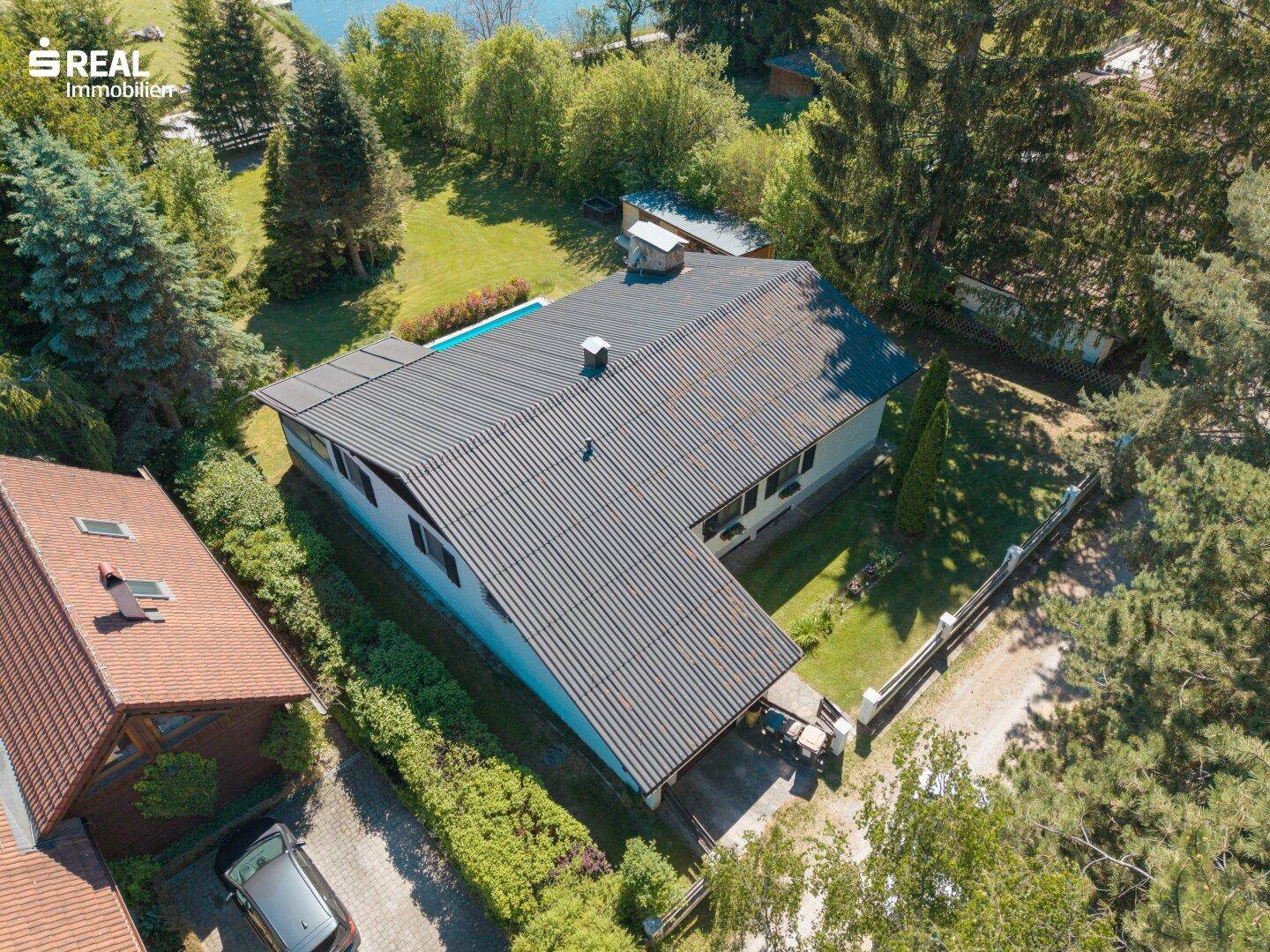 Luftaufnahme des Hauses in ländlicher Umgebung, umgeben von viel Grün und weiteren Gebäuden.