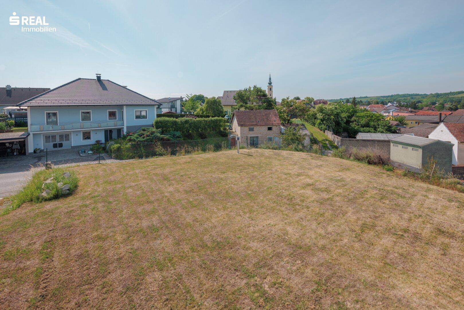 Großes Grundstück mit Rasenfläche und Blick auf die umliegende Wohnbebauung.