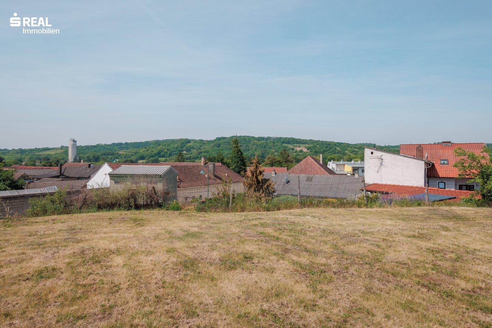 Weitläufiger Blick über die ländliche Umgebung mit Hügeln und Häusern.