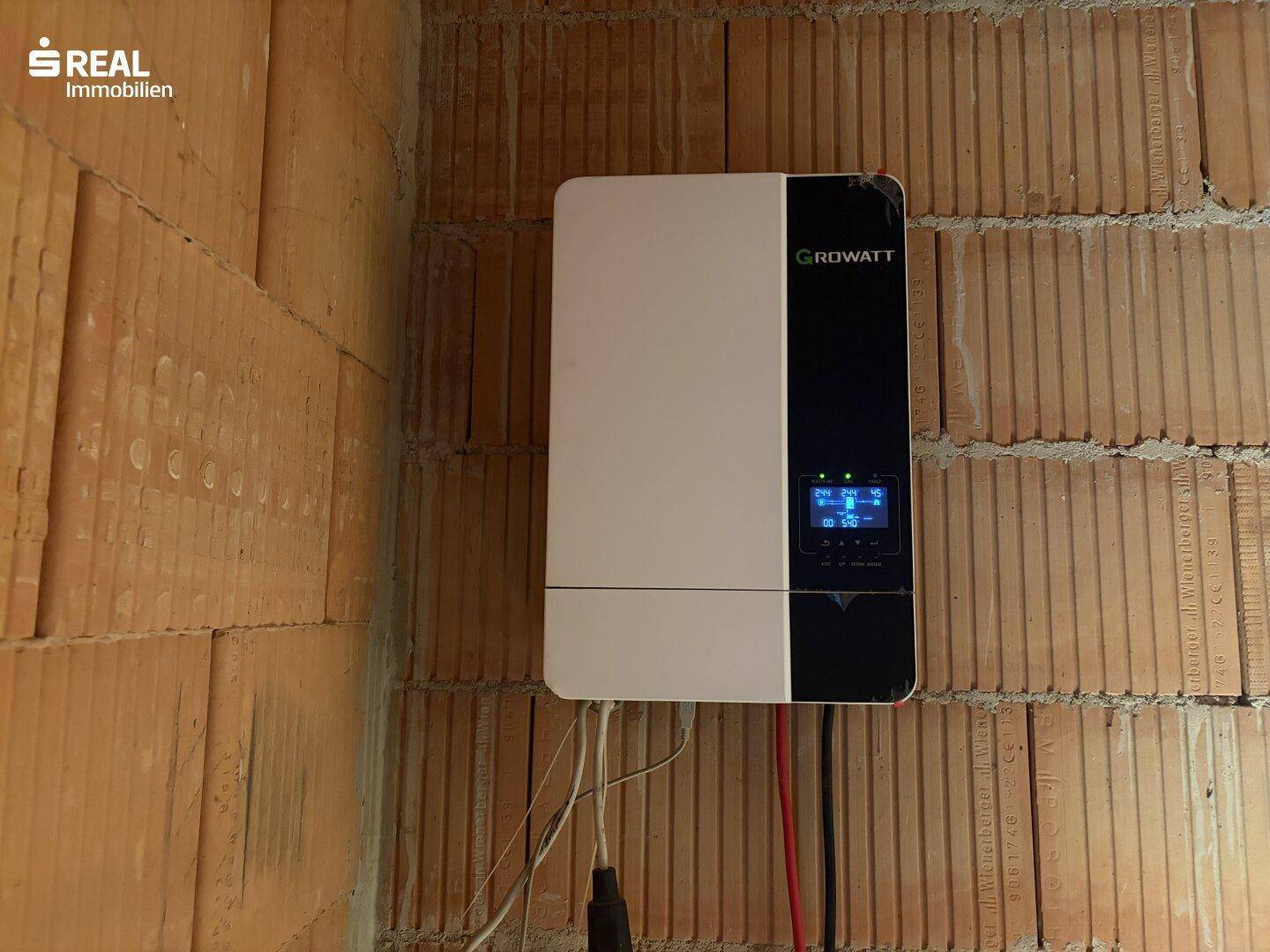 Growatt Wechselrichter für eine Photovoltaikanlage an der Ziegelwand montiert.