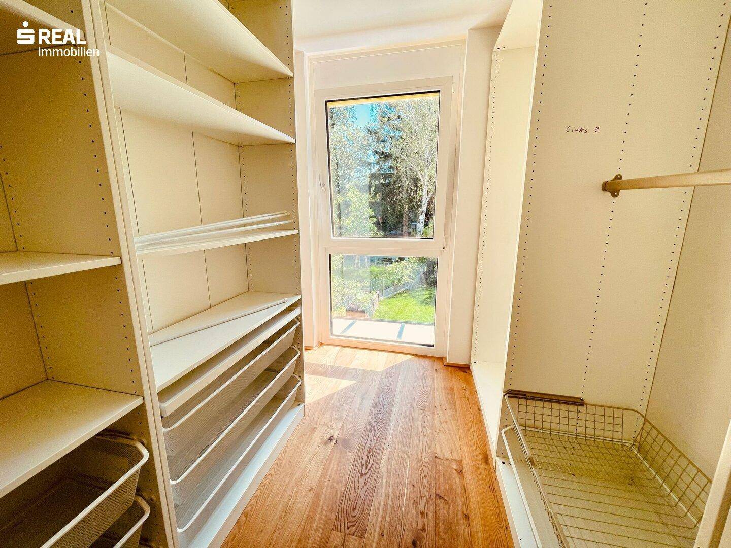 Praktischer begehbarer Kleiderschrank mit Regalsystemen und Fenster für natürliches Licht.