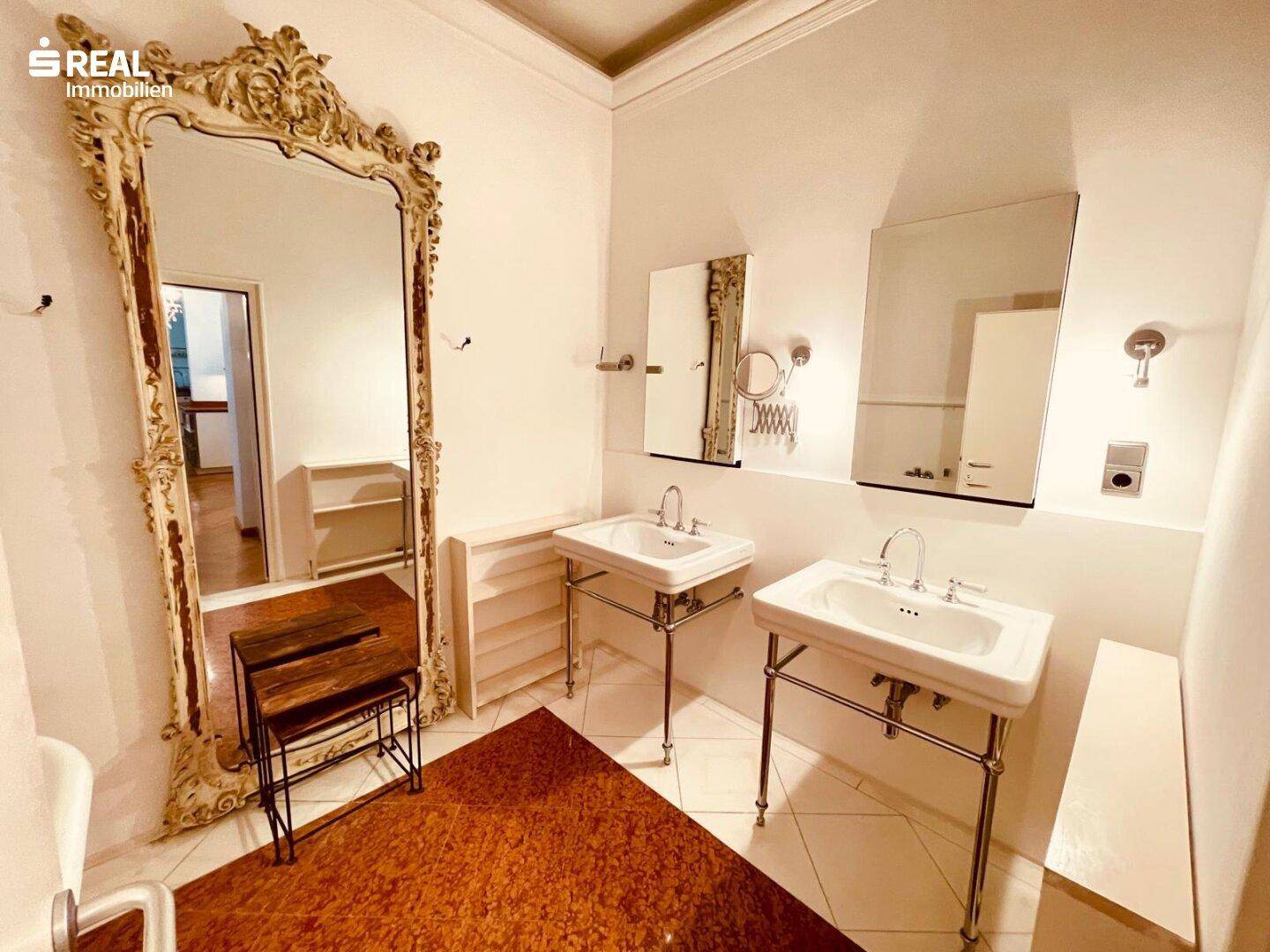 Geräumiges Badezimmer mit Doppelwaschbecken, großem Spiegel und Fliesenboden, modern und funktional gestaltet.