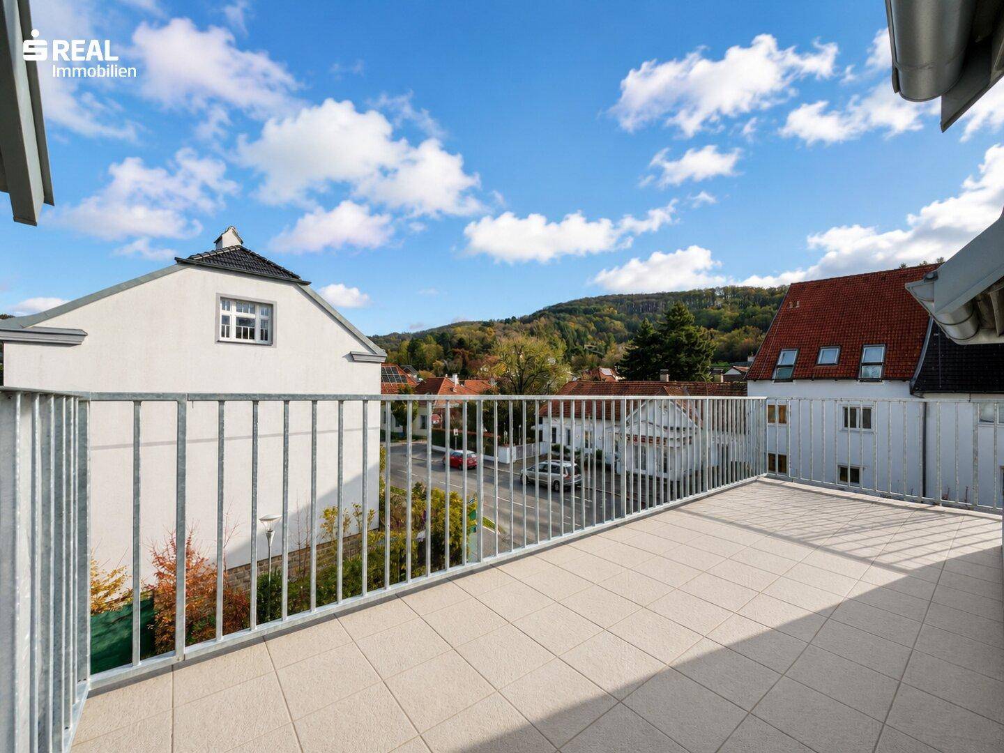 Großer Balkon mit Fliesenboden und weitem Blick über die Dächer der Nachbarschaft.
